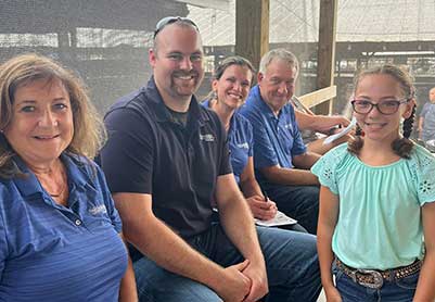 Group of Friendship State Bank employees with 4-H participate at the Jefferson County Livestock Auction.