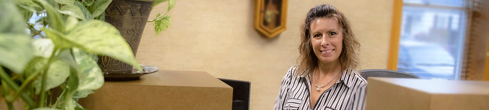 Smiling Friendship State Bank Branch Manager at the teller line inside Friendship State Bank.