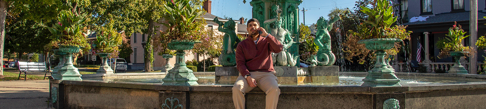 Man talking on phone at the Broadway Fountain in Madison, Indiana.