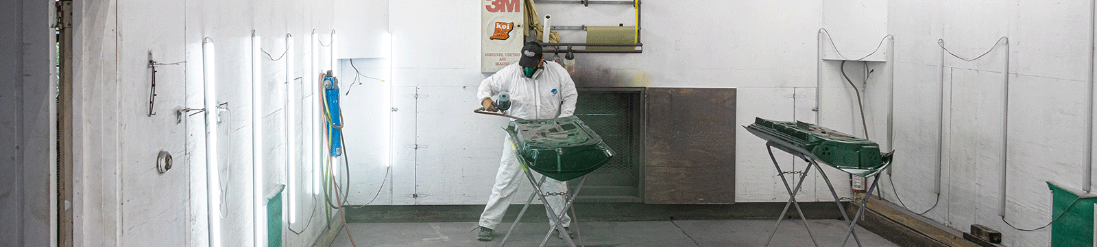 Autobody business owner painting car door panels.